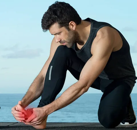 An athlete holding his leg suffering from a foot stress fracture in Millsboro and Seaford, DE