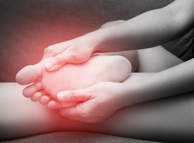 A woman in Millsboro and Seaford, DE, suffering from Sesamoiditis is touching her feet in pain.